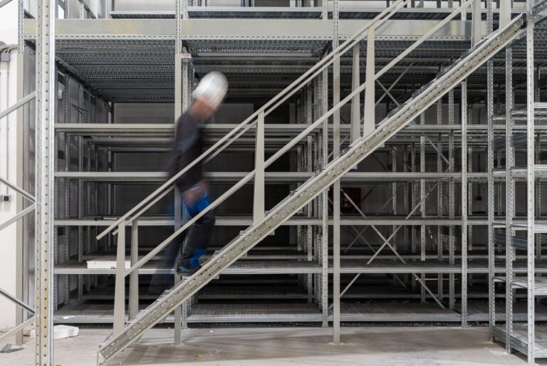 Operaio al lavoro nel posizionamento di scaffalature industriali